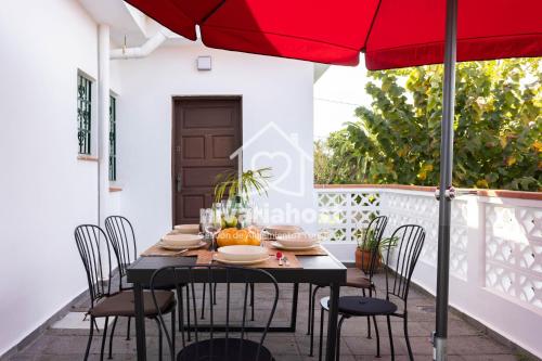 a table with chairs and an umbrella on a balcony at Tegas: Tacoronte, by Nivariahost in Tacoronte