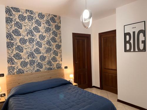 a bedroom with a blue bed and a wall at Aliss Home ASSISI in Bastia Umbra