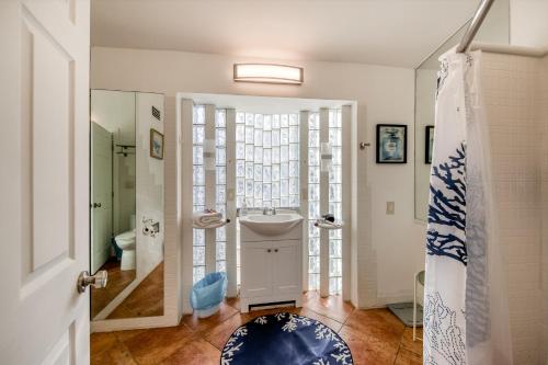 baño con ducha, aseo y puerta en Casa De Las Olas, en Fort Lauderdale