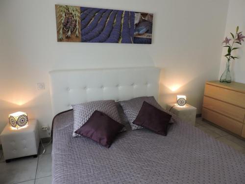 - une chambre avec un lit doté d'oreillers violets et de 2 lampes dans l'établissement La Villa Sepia - Piscine privée et chauffée, à Montblanc