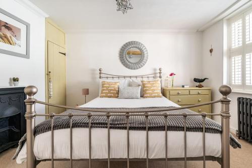 a bedroom with a bed and a mirror on the wall at Bijou Cottage in Deal