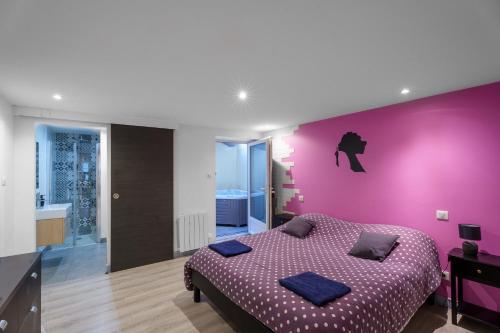 um quarto com uma parede roxa e uma cama em Appartement spa privatif et cinéma centre ville em Metz