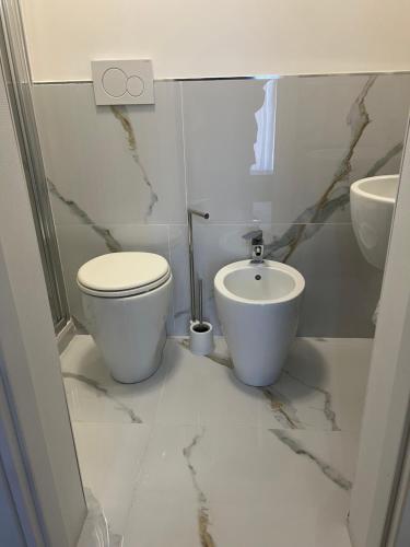 a white bathroom with a toilet and a sink at Duca di Uzeda Bed & Breakfast Luxury and Style in Catania