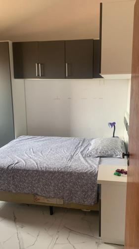 a bedroom with a bed and a table and cabinets at Casa com 4 quartos e piscina pra aproveitar in Tramandaí