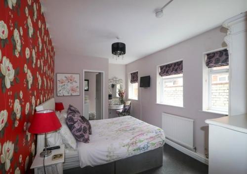 a bedroom with a bed and a red wall at The Regent Apartment 2 in Blackpool