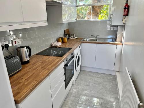 a white kitchen with a sink and a stove at Affordable 2 bedroom flat Tower Bridge/Bermondsey in London