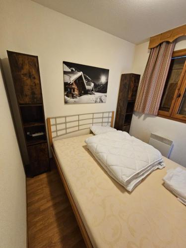 une chambre avec un grand lit avec des draps blancs dans l'établissement Les 3 Vallées - Hameau des eaux d'Orelle - Appartement 003, à Orelle