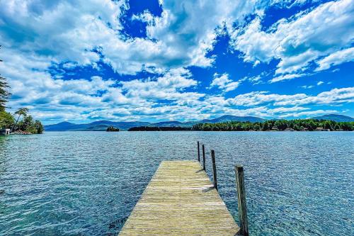 a wooden dock on a lake under a cloudy sky at Built with Love in Bolton Landing