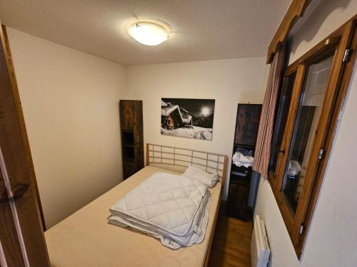 1 dormitorio pequeño con 1 cama en una habitación en Les 3 Vallées - Hameau des eaux d'Orelle - Appartement 003, en Orelle