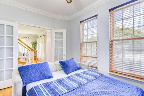 1 dormitorio con 1 cama con almohadas y ventanas azules en Historic District Magic Hideaway!, en Manassas