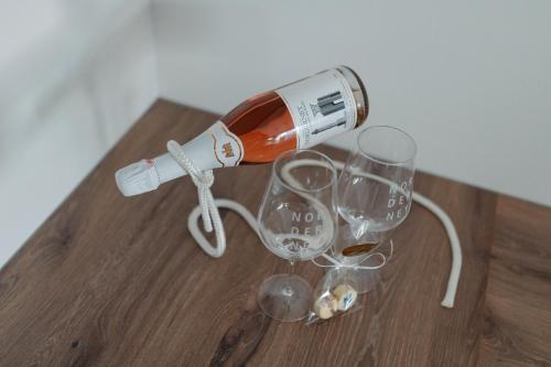 a bottle of wine and two wine glasses on a table at Haus Noena - Wohnung 7 Inselschatz in Norderney