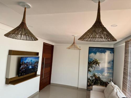 ein Wohnzimmer mit drei Kronleuchtern, die von der Decke hängen in der Unterkunft Apartamento Tulum in Barra Grande