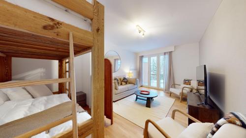 a bedroom with a bunk bed and a living room at Le Belvedere By Alaïa in Crans-Montana