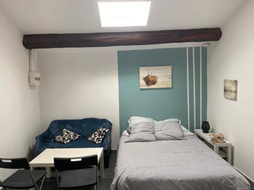 une chambre avec un lit, une table et une chaise dans l'établissement Studio 20 m2 meublé à 50 m de la Gare, à Sète