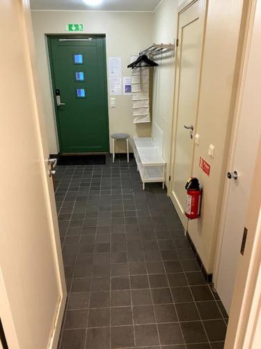 a bathroom with a green door and a tile hallway at Fjäll-lägenhet med fantastisk utsikt in Riksgränsen
