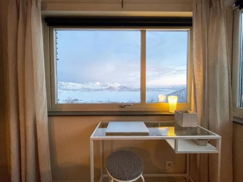 a desk in front of a large window with a laptop at Ski in ski out lägenhet med fantastisk utsikt in Riksgränsen