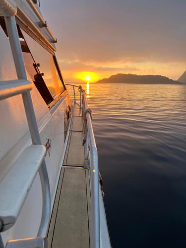 un barco con muelle en el agua al atardecer en Passeios Privativos de Lancha RJ en Río de Janeiro