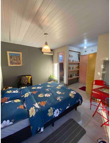 sypialnia z niebieskim łóżkiem z kwiatami w obiekcie Espaço privativo, funcional e aconchegante w mieście Santana do Livramento