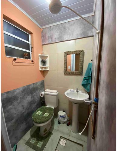 a small bathroom with a toilet and a sink at Espaço privativo, funcional e aconchegante in Santana do Livramento