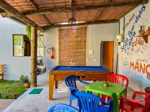 a pool table in a room with red and blue chairs at Recanto Manoah, TERRA in Caraíva