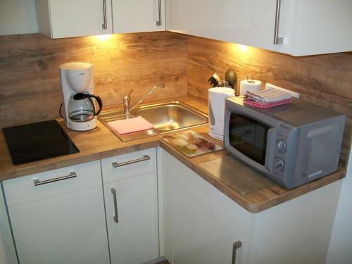 eine Küchentheke mit Mikrowelle und Spüle in der Unterkunft Strandappartement in Westerland