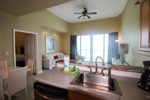 a kitchen with a sink and a living room at Castle Ph2 Balcony Oceanfront Condo, Beach Access, Pool, Tennis, Free Parking in Miami Beach