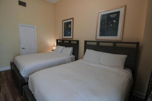 two beds in a hotel room with white sheets at Castle Ph2 Balcony Oceanfront Condo, Beach Access, Pool, Tennis, Free Parking in Miami Beach