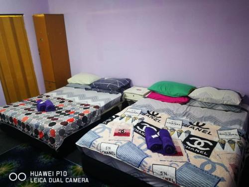 two beds sitting next to each other in a room at Homestay Teratak Tuan Muda in Air Molek