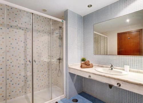 un bagno con doccia, lavandino e specchio di Be HAPPY 77 ad Arona