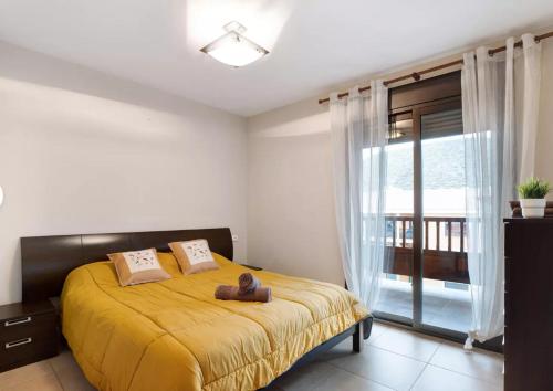 una camera da letto con un letto con una coperta gialla di Be HAPPY 77 ad Arona