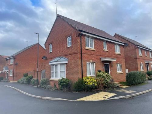 a red brick house on the side of a street at Beautiful Family Home in Mickleover