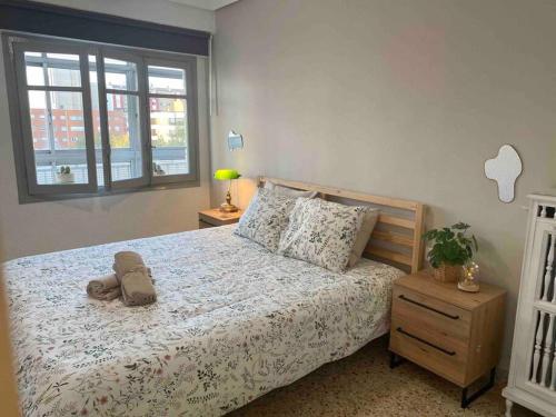 un dormitorio con una cama con un animal de peluche en Acogedor apartamento a 5 min del Ave en Zaragoza