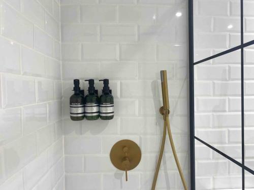 een badkamer met drie flessen aan de muur bij Acogedor apartamento a 5 min del Ave in Zaragoza
