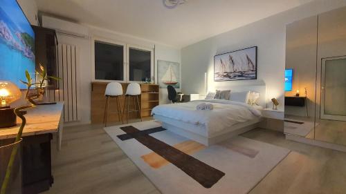 a bedroom with a bed and a desk and windows at Negotin Centar Apartman II in Negotin