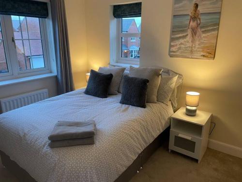a bedroom with a bed with blue pillows at Beautiful Family Home in Mickleover