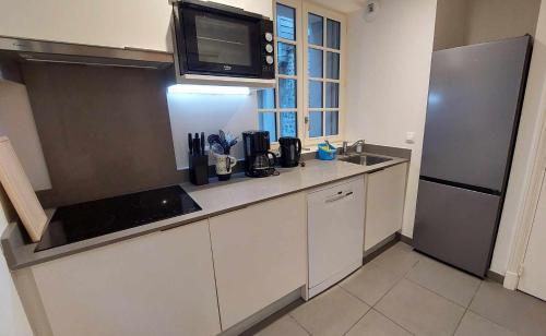 une cuisine avec un évier et un réfrigérateur dans l'établissement Appartement familial au cœur de Dieppe, à Dieppe