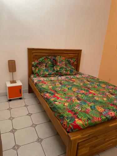 a bedroom with a bed with a colorful comforter at Case colorée in Saint-Joseph