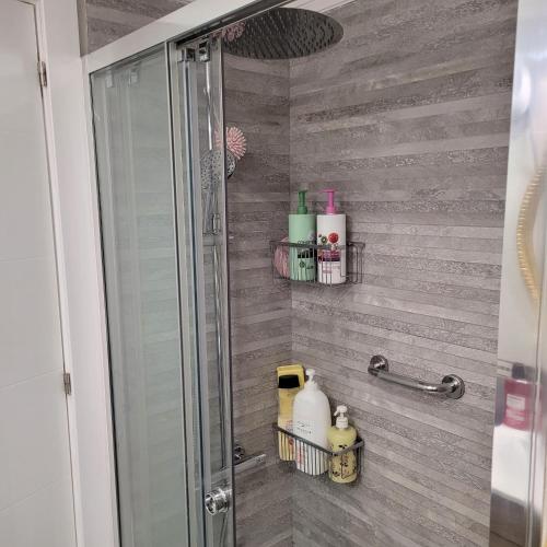 een badkamer met een douche met zeep en toiletartikelen bij Shared accommodation a room with a view of the garden in Sevilla
