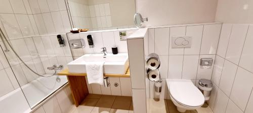 a white bathroom with a sink and a toilet at Wirtshaus Leindl in Krems an der Donau