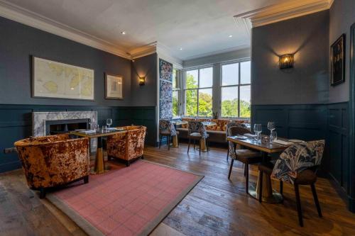 un ristorante con tavoli, sedie e un camino di Duisdale House Hotel a Isleornsay