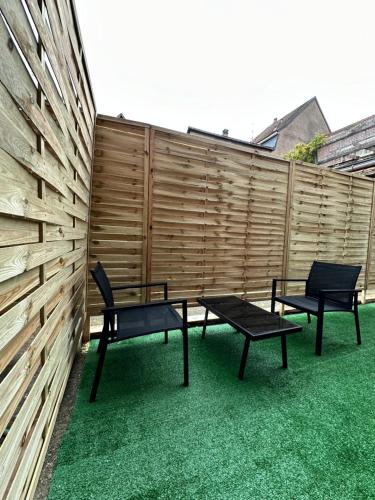 two chairs and a table in front of a fence at Appartement cosy jacuzzi spa 70M2 in Châtenois