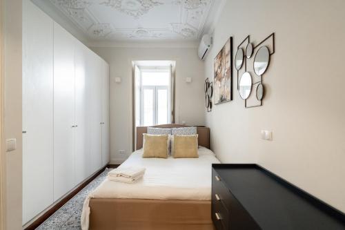 a bedroom with a bed and a black dresser at Akicity Saldanha White in Lisbon