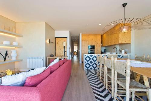 a living room with a pink couch and a kitchen at Boutique Rentals- AL MAR Beachfront in Póvoa de Varzim