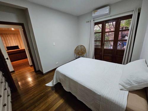 a bedroom with a white bed and a window at Apartamento bien localizado in Ciudad del Este