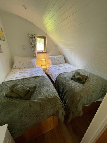 two beds in a room with a attic at Wimbish Hall Cabins in Wimbish