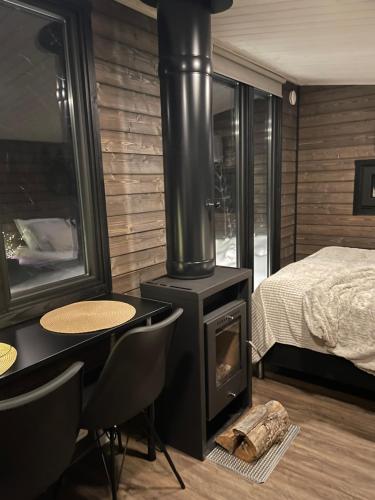 - une chambre avec une cuisinière et un lit dans l'établissement Tunnelmallinen ja ihana mökki, à Rovaniemi