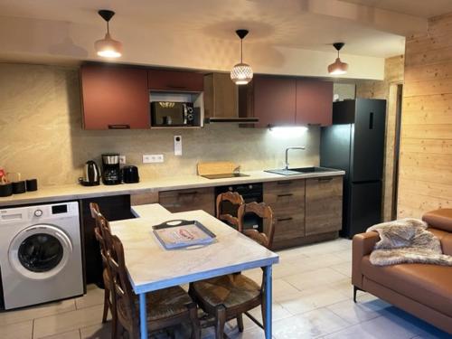 a kitchen with a table and a kitchen with a dishwasher at Le Logis de Bamby in Ancelle