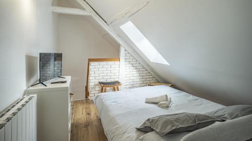 une chambre avec un lit dans un grenier dans l'établissement Secret de la Monnaie - Duplex - 2 Personnes - Rue Historique de Troyes, à Troyes