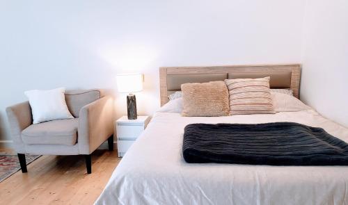 ein Schlafzimmer mit einem Bett und einem Stuhl in der Unterkunft Cosy Studio-House with Terrace in Târgu Mureș