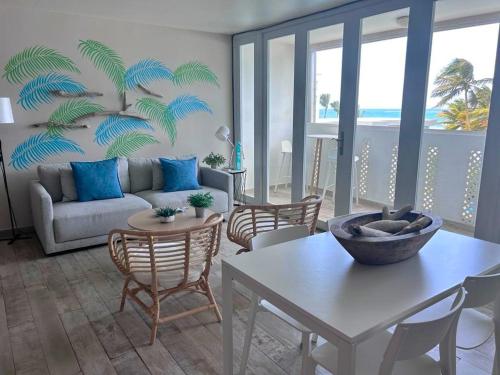 uma sala de estar com um sofá e uma mesa em KASA Brisa Marina - 1 bed 1 bath for 2 OCEAN VIEW BALCONY BEACHFRONT CONDO POOL em San Juan